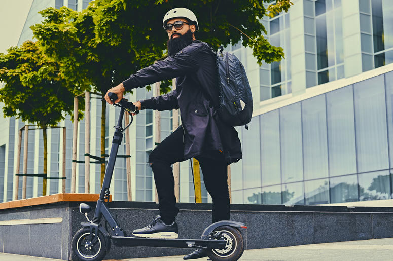 Un homme sur une trottinette Utiliser une trottinette électrique est dangereux pour votre santé